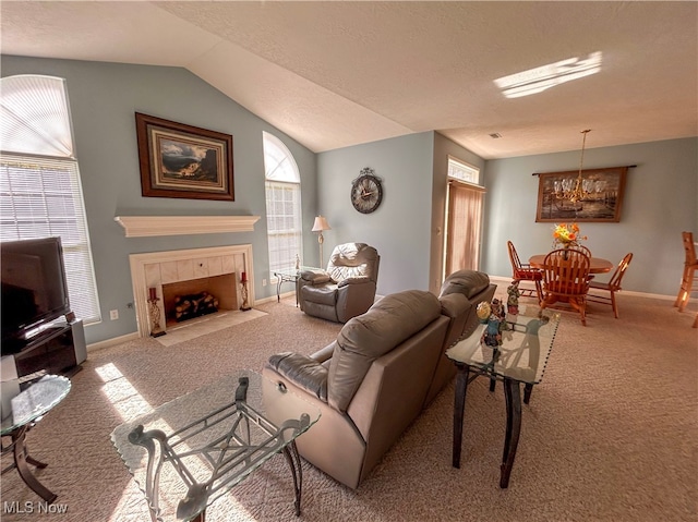 living room with light carpet, a tile fireplace, vaulted ceiling, a chandelier, and a textured ceiling