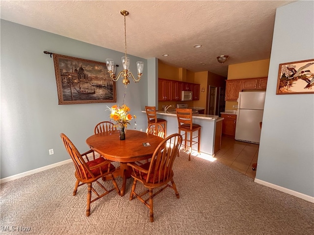 dining room featuring sink, light carpet, a textured ceiling, and an inviting chandelier