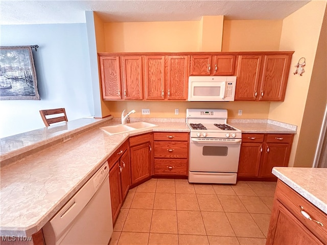 kitchen with white appliances, light tile patterned floors, a textured ceiling, and sink