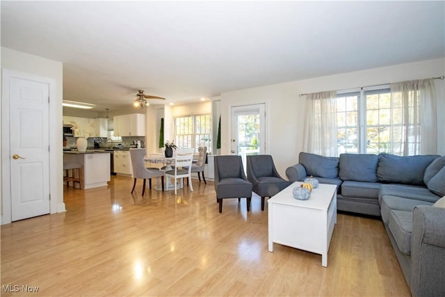 living room with light wood-type flooring and ceiling fan