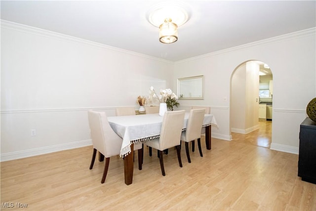 dining area featuring light wood-type flooring and crown molding