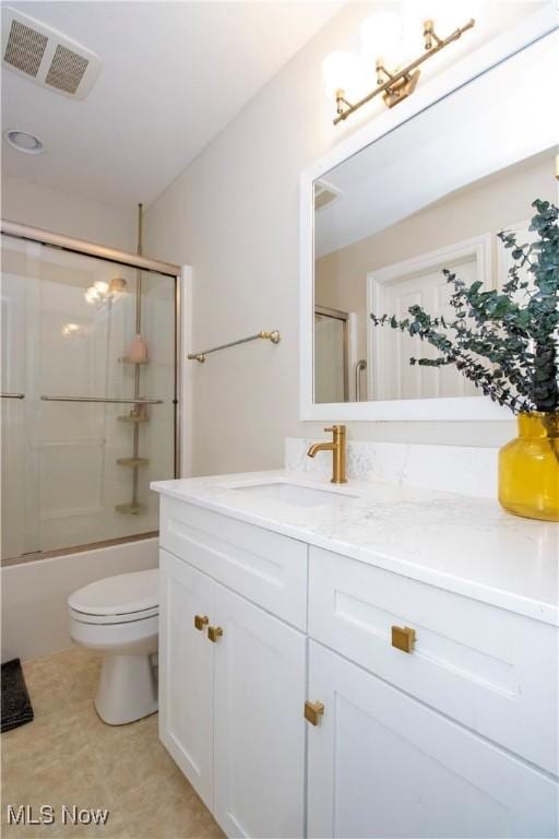 full bathroom with toilet, vanity, and bath / shower combo with glass door