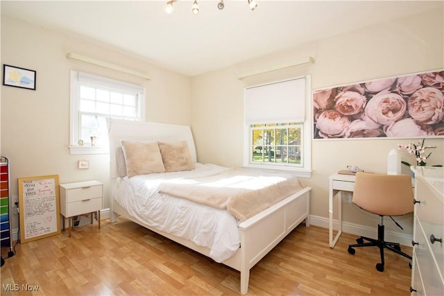 bedroom featuring light hardwood / wood-style flooring and multiple windows