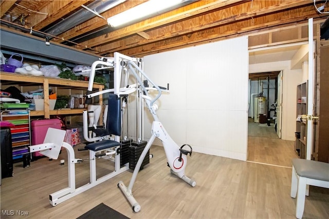 workout area featuring gas water heater and hardwood / wood-style flooring