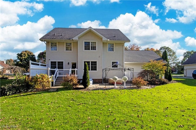 back of property featuring a yard, a deck, and a gazebo