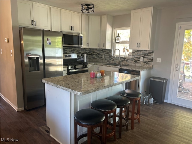 kitchen with a center island, stainless steel appliances, sink, and plenty of natural light