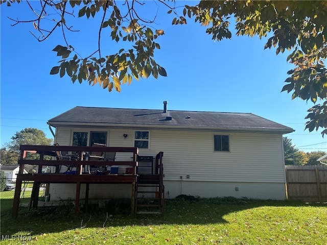 rear view of property featuring a wooden deck and a yard