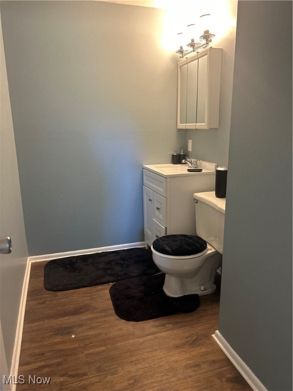 bathroom featuring vanity, toilet, and hardwood / wood-style floors