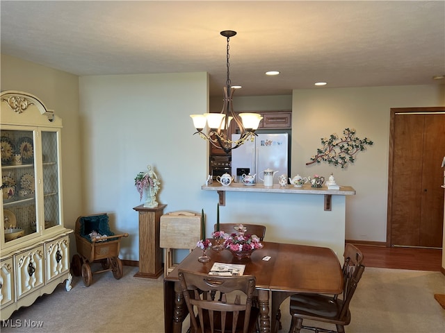 dining room with a chandelier and light colored carpet