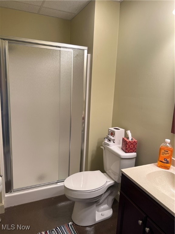 bathroom featuring vanity, a paneled ceiling, toilet, and walk in shower