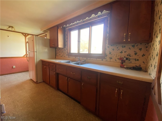 kitchen featuring sink, white fridge, and dark brown cabinets