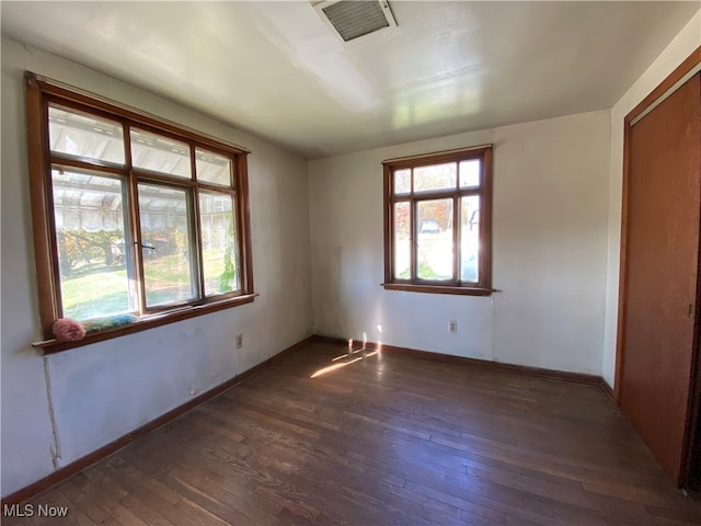 unfurnished room with dark hardwood / wood-style flooring