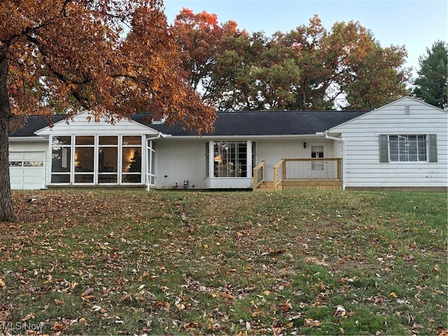 back of house featuring a lawn and a sunroom