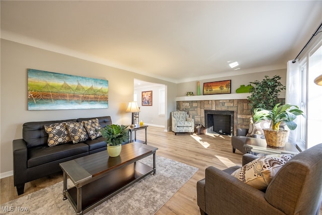 living room with a fireplace and light wood-type flooring