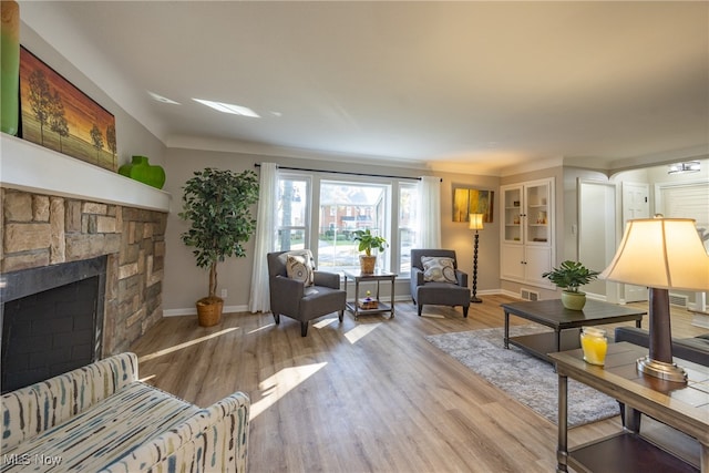 living room with a fireplace and light wood-type flooring