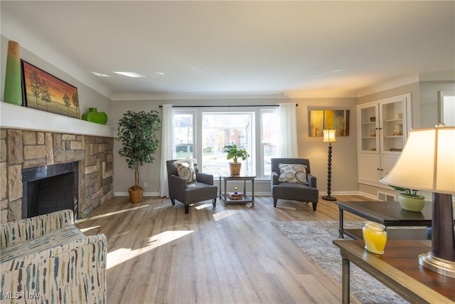 living room featuring light hardwood / wood-style floors, a fireplace, and built in shelves