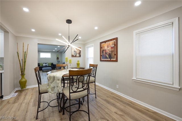 dining space featuring a notable chandelier and light wood-type flooring