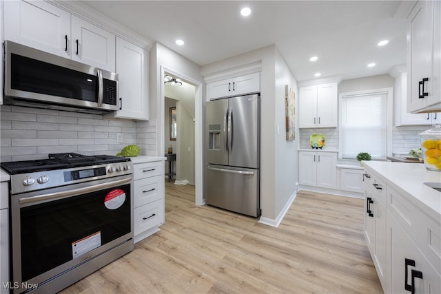 kitchen with light hardwood / wood-style floors, appliances with stainless steel finishes, and white cabinets