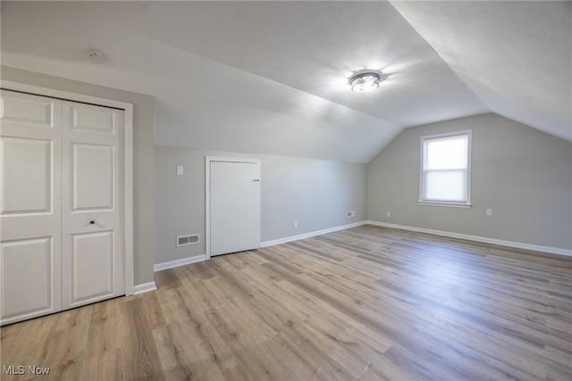 bonus room with lofted ceiling and light hardwood / wood-style flooring