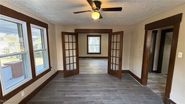 interior space featuring french doors, dark hardwood / wood-style floors, a textured ceiling, and ceiling fan