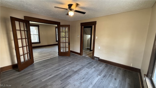 empty room with french doors, dark wood-type flooring, a textured ceiling, and ceiling fan