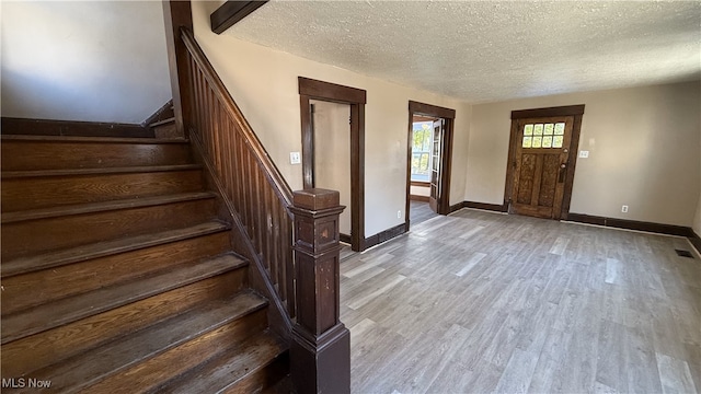 foyer with a textured ceiling and light hardwood / wood-style floors