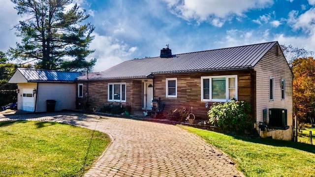 single story home with a front yard, a garage, and central AC unit