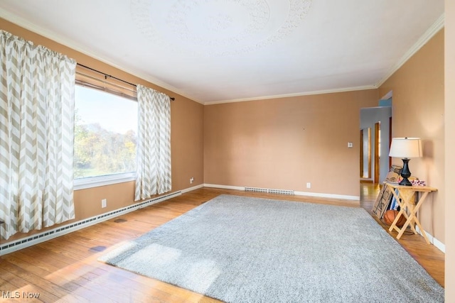 unfurnished room with crown molding, wood-type flooring, and a baseboard heating unit