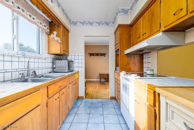 kitchen featuring tasteful backsplash, sink, electric stove, tile countertops, and light tile patterned floors