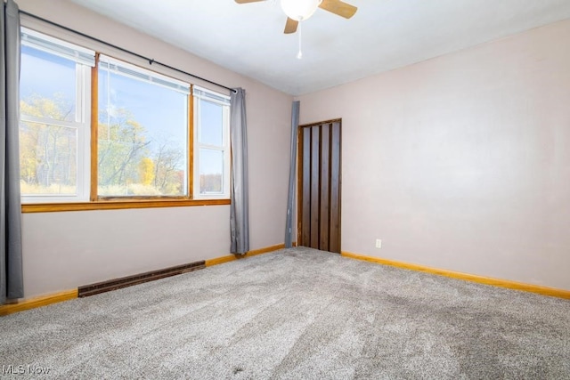 carpeted spare room featuring ceiling fan