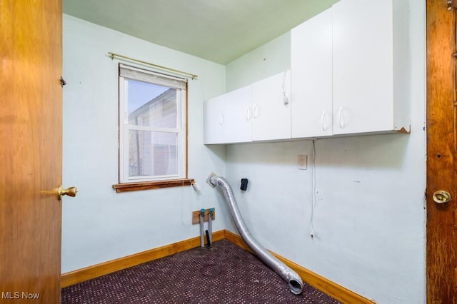 laundry area with hookup for an electric dryer and cabinets