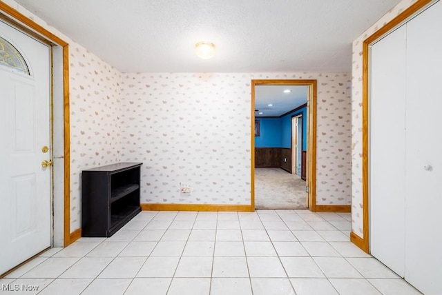 unfurnished living room with a textured ceiling and light tile patterned floors