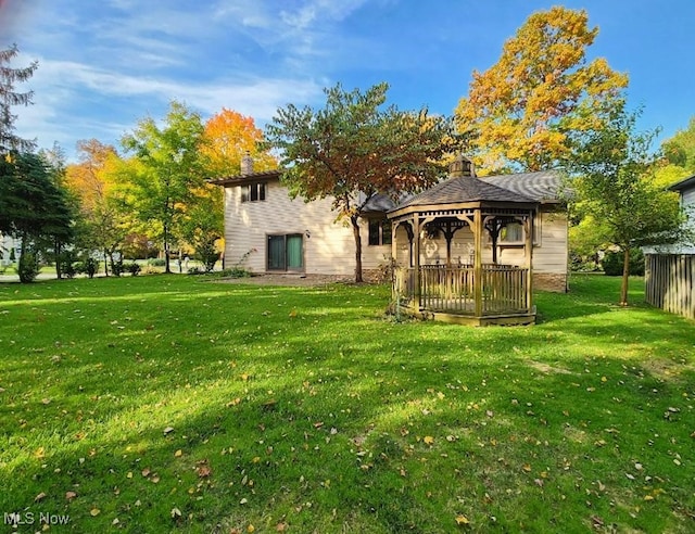 back of property featuring a gazebo and a lawn