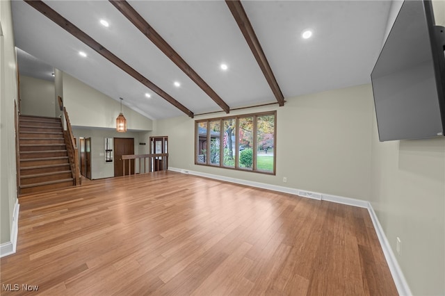 unfurnished living room with lofted ceiling with beams and light wood-type flooring