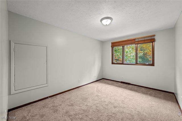 unfurnished room with a textured ceiling and carpet floors