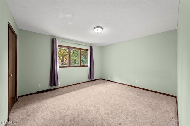 unfurnished room with a textured ceiling and carpet