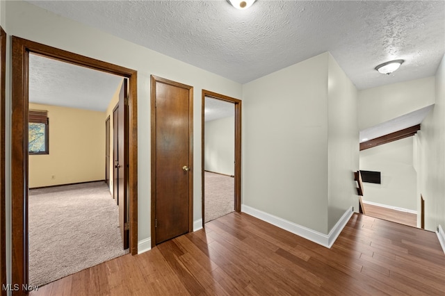 corridor featuring hardwood / wood-style floors and a textured ceiling