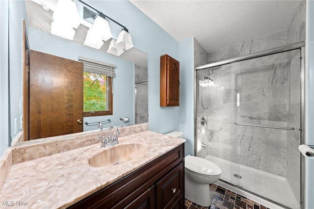 bathroom with vanity, toilet, and a shower with shower door