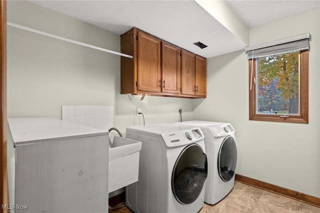 laundry room featuring separate washer and dryer and cabinets