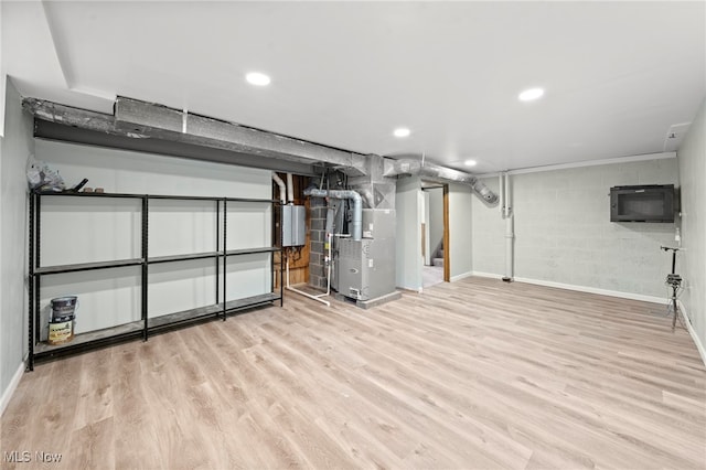 basement with water heater, heating unit, and light hardwood / wood-style floors