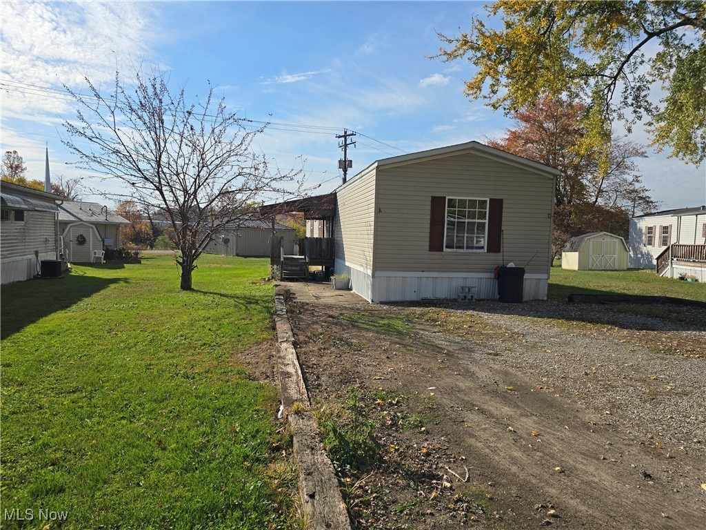 view of home's exterior featuring a yard, a shed, and central air condition unit