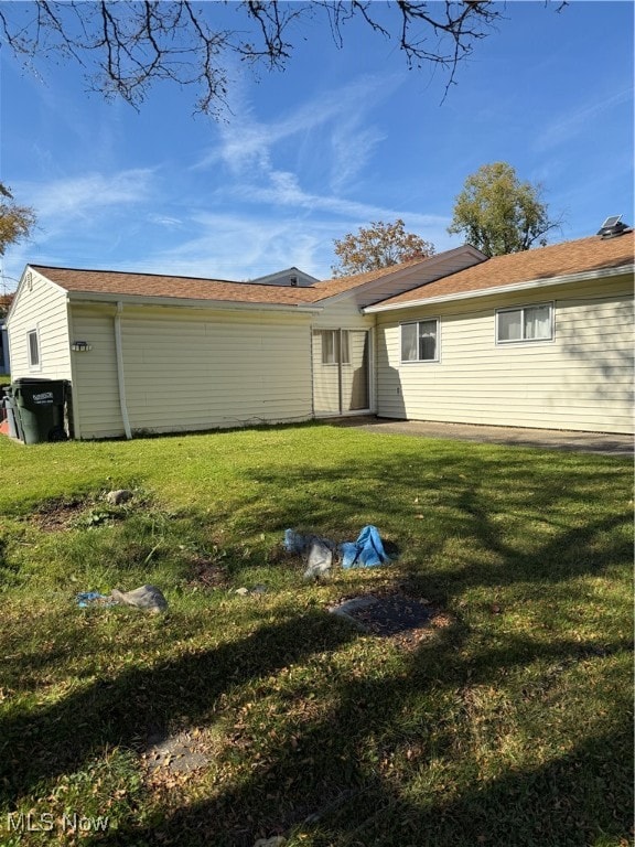 back of house with a lawn