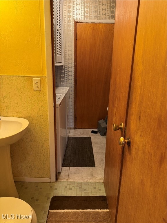 bathroom with toilet and washer / clothes dryer