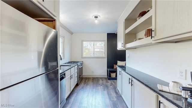 kitchen with white cabinets, dark stone counters, dark hardwood / wood-style floors, sink, and stainless steel appliances