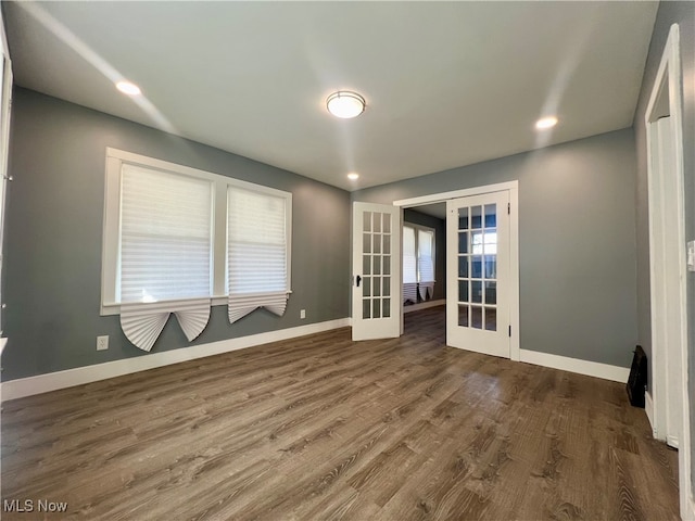 spare room with french doors and dark hardwood / wood-style floors