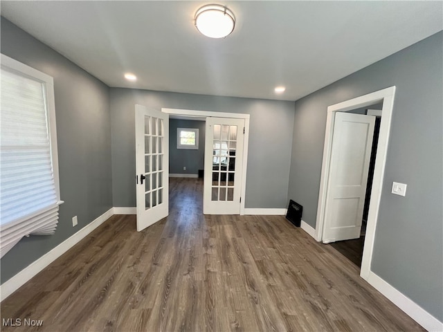 unfurnished room with french doors and dark wood-type flooring