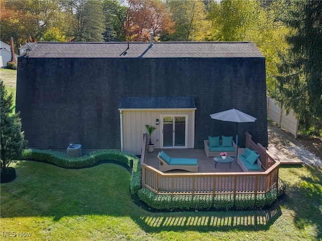 back of property featuring a wooden deck, outdoor lounge area, and a yard