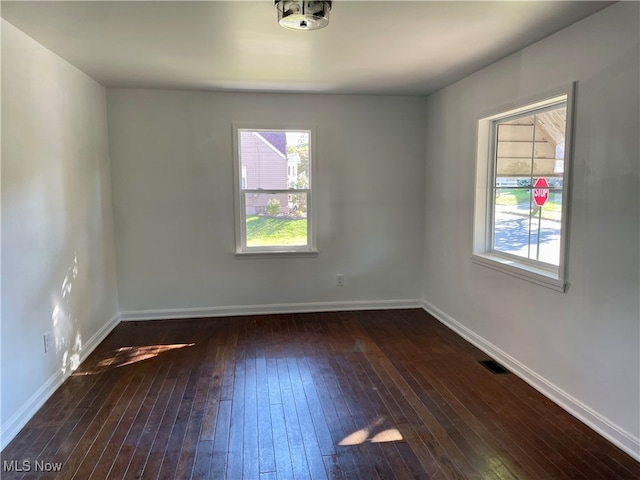 unfurnished room with dark wood-type flooring and plenty of natural light