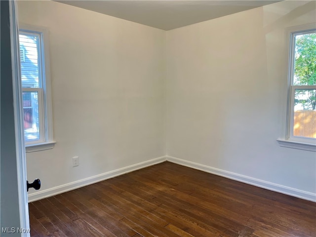 empty room with dark hardwood / wood-style floors