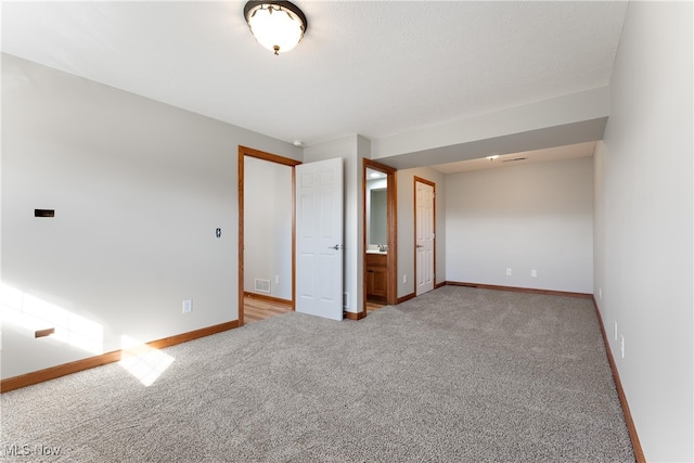 unfurnished bedroom featuring connected bathroom and carpet floors